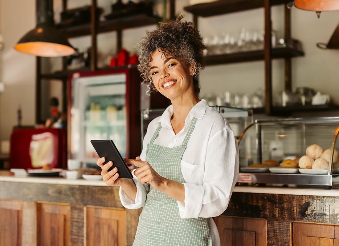 We Are Independent - Portrait of a Cheerful Young Female Small Business Owner Standing in her Cafe While Holding a Tablet in her Hands